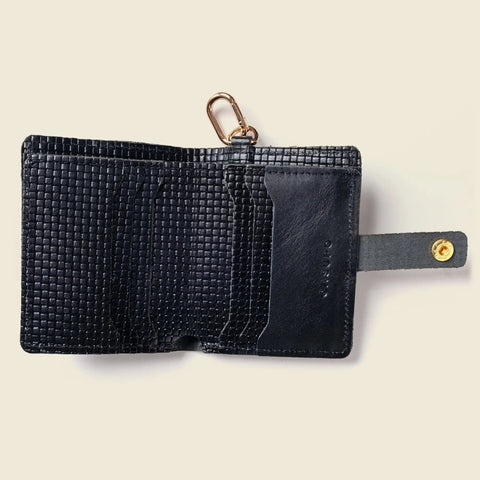 The CASUPO Wallet With Snap and Key Ring - Black Limited Edition is crafted from eco-friendly leather and features multiple card slots, a snap closure, and a gold key ring, shown open on a light background.