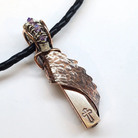 The Memorial Birthstone Angelwing Necklace-Limited Special Edition 2020-2024 by Alexa Martha Designs features a hammered copper pendant with an engraved cross and purple gemstones on a black braided leather cord—an elegant tribute to loved ones.
