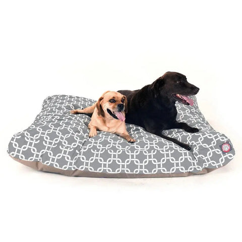 A small tan dog and a large black dog lie together on the Majestic Pet Links Rectangle Dog Bed, featuring a white geometric pattern. Both look relaxed and happy, enjoying the comfort of premium polyester fiber fill.