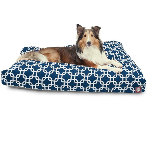 A brown and white dog is lying on the Majestic Pet Links Rectangle Dog Bed, featuring a navy blue, washable cover with a white geometric pattern and premium polyester fiber fill for ultimate comfort.