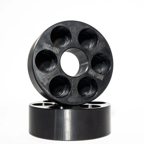 Two black Weight It Out Lock and Load Revolver Micro Loading Plates, each with six large holes around a central hole and a polished finish, are stacked against a white background, showcasing their customizable design for workouts.