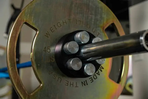 Close-up of a 45-pound Lock and Load Revolver Micro Loading Plate by Weight It Out, engraved with 45 LBS and MADE IN THE USA, mounted on a barbell to showcase precise, customizable workout options.