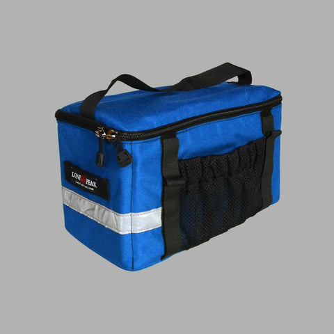 A blue rectangular Lone Peak Basic Rack Pack by Lone Peak Packs with black handle, black zippers, reflective silver stripe, mesh side pocket, and side logo patch, shown against a plain gray background.