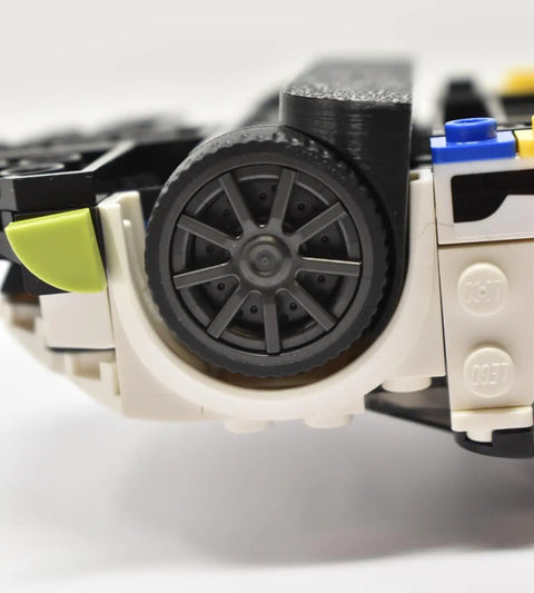 A LEGO car model is displayed on a Chatelet Manufacturing Low Profile Collectible Car Display Wall Mount (Black 3-Pack), compatible with LEGO cars, showing black wheels, gray spokes, white & black bricks, lime green and blue pieces. Made in USA.