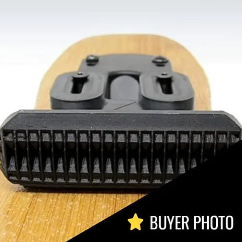 Close-up of a black snowboard binding on wood, featuring the Chatelet Manufacturing Low Profile Longboard or E-Skateboard Foot Stop for improved traction, balance, and control. BUYER PHOTO text and a yellow star are in the lower right corner.