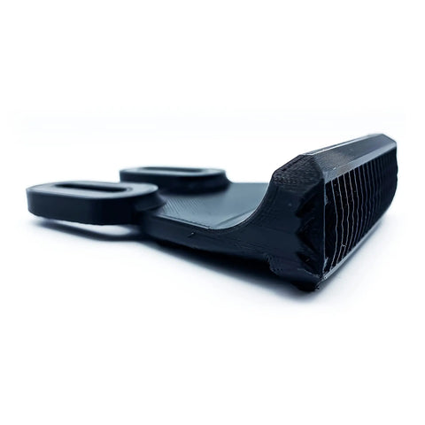 Close-up of a Chatelet Manufacturing Low Profile Longboard or E-Skateboard Foot Stop in black PETG carbon fiber, featuring two looped handles and a textured edge for improved traction, balance, and control. Perfect accessory for longboards or e-skates.