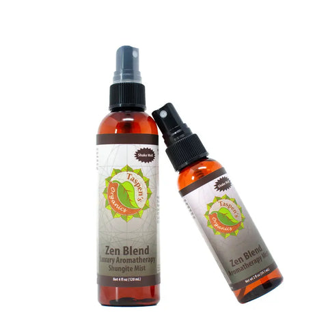 Two amber spray bottles labeled Taspens Organics Luxury Aromatherapy Shungite Mists, featuring green and orange accents—one upright, one tilted—display an energy-balancing formula made with organic essential oils on a white background.