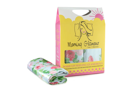 The Morning Glamour Satin Pillowcase Standard/Queen 2PK (Multiple Print Options) is shown with its yellow and white packaging featuring a womans illustration and branding—designed to help reduce frizz and keep you feeling glamorous.