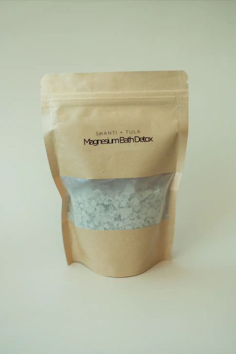 A brown resealable pouch labeled Shanti + Tula Magnesium Detox Bath Soak with Lavender & Bentonite Clay stands upright against a plain background, offering a magnesium-rich soak for relaxation and sleep support. Made in the USA.