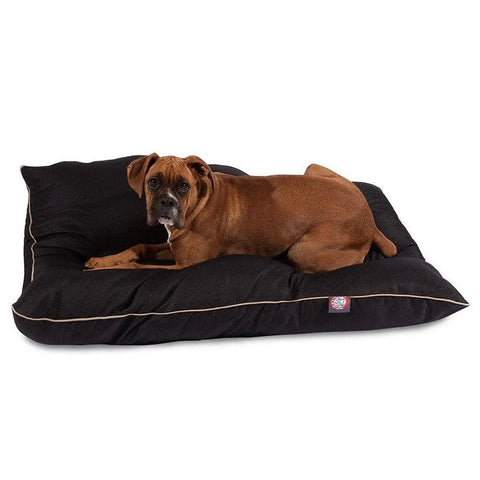 A brown dog rests on a Majestic Pet Poly/Cotton Super Value Dog Bed with light piping and a small logo tag, set against a white background.