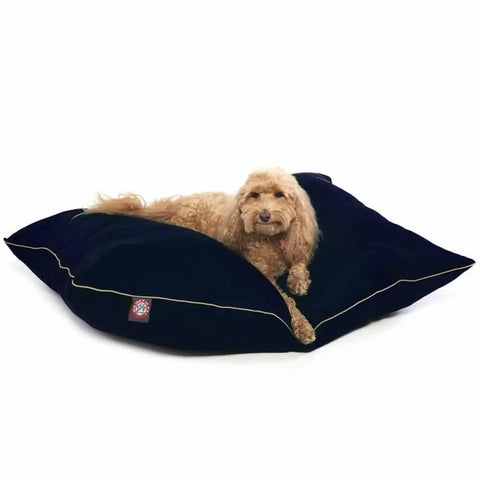 A fluffy light brown dog relaxes on a Majestic Pet Poly/Cotton Super Value Dog Bed, featuring dark blue velvet with beige piping. The hypoallergenic poly-cotton ensures your pup stays comfortable and content.