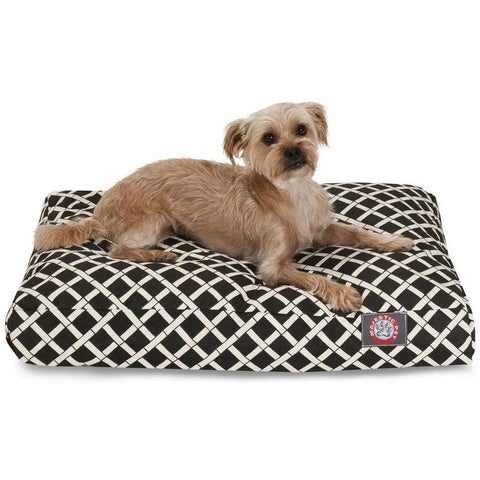 A small, light brown dog lies on the Majestic Pet Bamboo Rectangle Dog Bed with a black and white checkered design and a red and white logo patch, keeping comfy with front paws stretched out. The washable bed ensures your pets comfort.