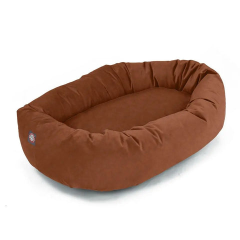 The Majestic Pet Suede Bagel Dog Bed features a brown oval design with raised cushioned sides and a soft, flat polyester faux suede surface for comfort.