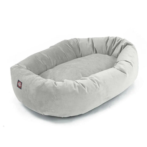 The Majestic Pet Velvet Bagel Dog Bed in light gray features an oval shape with raised sides and a soft, cushioned base for gentle spine support, shown on a white background.