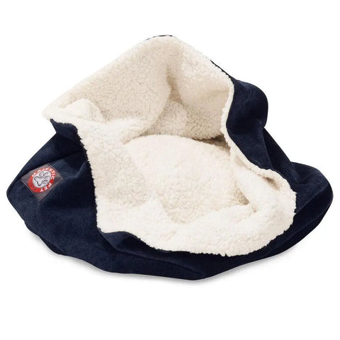 The Majestic Pet Villa Burrow Cat Bed is a cozy, navy blue faux suede cat bed with cream fleece lining and a red paw print patch, designed for feline comfort, shown empty and slightly crumpled.