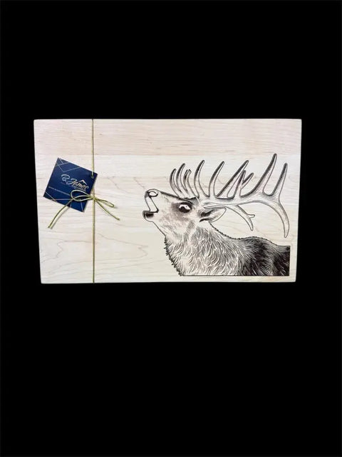 The Elk Epoxy Inlay Board by B. James Design & Woodwork features an engraved elk with antlers. A business card, tied with twine, is attached to the board, set against a solid black background.