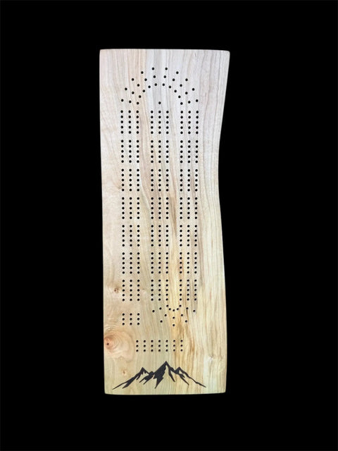 The B. James Design & Woodwork Maple Live Edge Cribbage Board With Mountain Engraving features handcrafted elegance, multiple scoring rows, and a striking mountain design at the bottom on a classic black background.