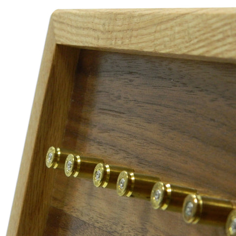Close-up of the ORIGINAL Brass Casing Challenge Coin Display - Medium by Legacies of America Woodworking Company, featuring several brass bullet casings mounted horizontally in a natural wood-finished case.