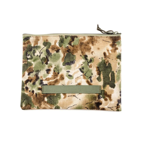 The MIS Tool Pouch M - Covert Woodland is a flat zippered Cordura Nylon bag with a green, brown, and beige camouflage pattern and a horizontal green strap on the front, shown against a white background.