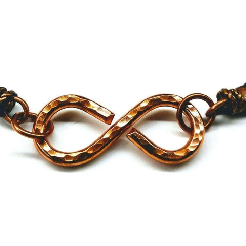 The Masculine Sturdy Copper Swivel Infinity Bracelet by Alexa Martha Designs features a hammered copper infinity symbol with two connecting rings on each side, attached to a chain and showcased on a white background.