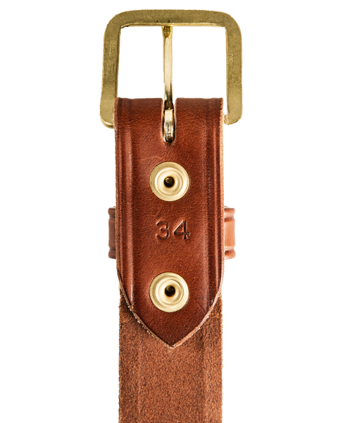 A close-up of the Homestead Brand Mens Americana Belt No. 1507, featuring full grain leather, a brass buckle, two gold rivets, and size 34 stamped between them; proudly made in the USA.