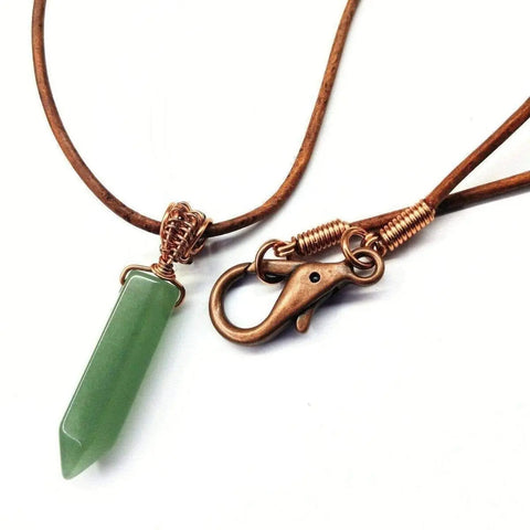 The Mens Rustic Wire Wrapped Pointed Gemstone Crystal Leather Necklace by Alexa Martha Designs features a handcrafted green crystal pendant on a brown leather cord with a copper clasp for unique, stylish appeal.