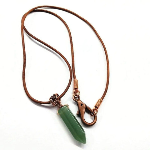 The Mens Rustic Wire Wrapped Pointed Gemstone Crystal Leather Necklace by Alexa Martha Designs features a green gemstone pendant on a brown leather cord, combining earthy elegance with vegan-friendly style for any look. Displayed on a white background.