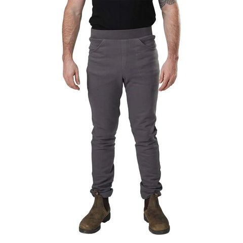 Only the lower half of a person is visible, showcasing Spiritex | Sustainable Apparels Saratoga Pants in gray high-waisted style, paired with a black t-shirt and brown boots against a white background.