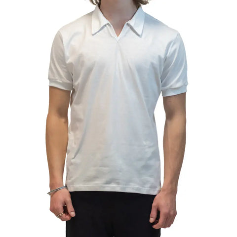 A person, head not visible, stands against a white background wearing the Short Sleeve Mt. Mitchell Collared Shirt by Spiritex | Sustainable Apparel in plain white organic cotton and dark pants.