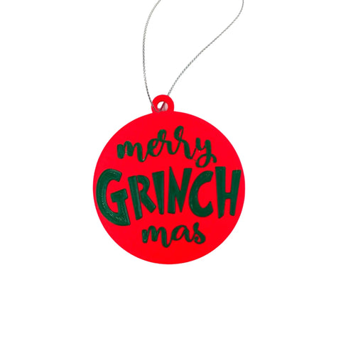 The Merry Grinchmas Christmas Ornament by Chatelet Manufacturing is a round red 3D printed holiday decoration with green and black text, hanging from a silver string. Made in the USA—perfect for adding unique cheer to your Christmas tree.