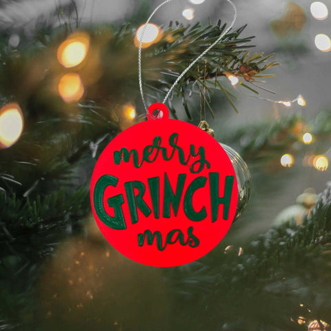 The Chatelet Manufacturing Merry Grinchmas Christmas Ornament, a festive holiday decoration made in the USA, features playful green and black lettering and adds cheerful style to your tree.