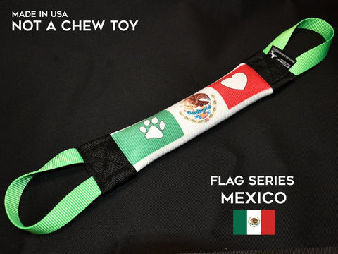 The Bulletproof Pet Products Inc Mexico Fire Hose Training Tug - Flag Series is a durable dog toy with green handles, a Mexican flag design, paw print and heart. Reads Made in USA, Not a Chew Toy. Inspired by the Mexico Fire Hose Training Tug.