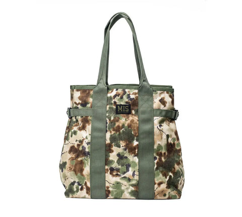 The MIS Multi Tote Bag - Covert Woodland features a green, brown, and beige camouflage pattern, water-resistant material, green straps and handles, a small black MIS patch on the front, and is proudly made in the USA.