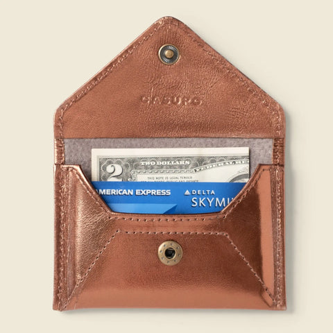 The CASUPO Mini Envelope Wallet With RFID Protection in bronze is a compact card holder with a snap button, light gray fabric lining, and eco-friendly leather. Inside, it fits cash and cards securely.