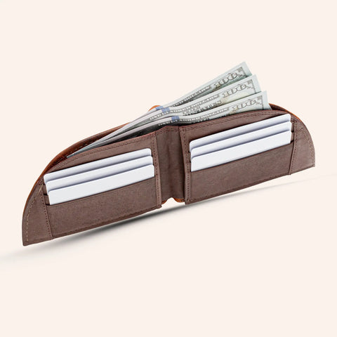 The Rogue Industries Rogue Front Pocket Wallet - Classic Made in Maine Edition, crafted from brown premium leather, is open to show four white cards and several $100 bills against a plain, light background.