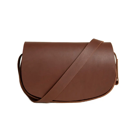 The Urban Southern Half Moon Crossbody is a minimalist brown full-grain leather handbag with a long strap and classic design, shown against a white background.