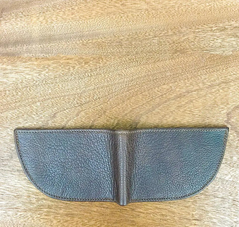 The Rogue Industries Nantucket Front Pocket Wallet, made of dark brown textured top-grain leather, is open and laid flat on a light wooden surface, highlighting its slim, minimalist design.