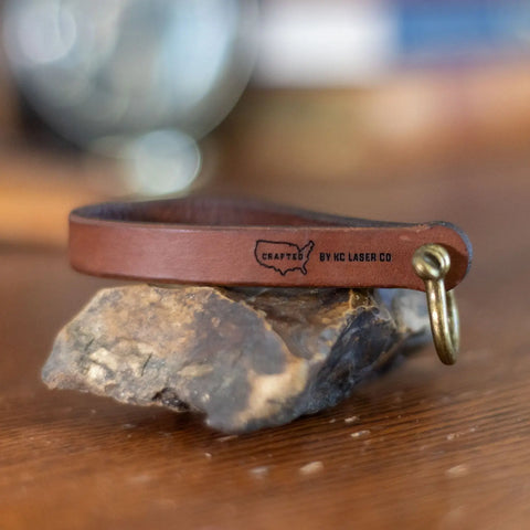 The Minimalist Leather Key Fob – Horseshoe Shackle Design by KC Laser Co is handcrafted in the USA, featuring a solid brass ring and stamped branding—ideal for fans of American-made goods.