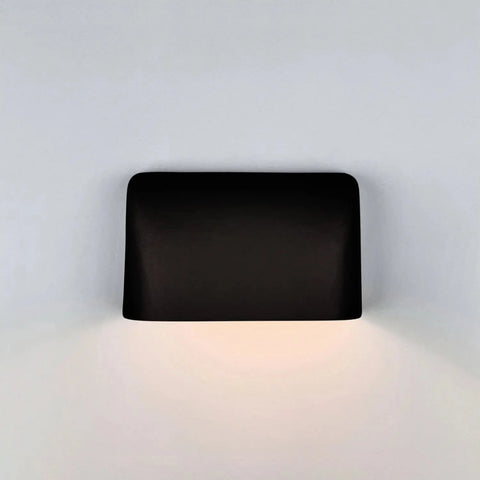 The Modern USA-Made Balboa Downlight Sconce by A19 Artisan Lighting, handcrafted in California, features a sleek black rectangular design with rounded corners and emits a soft white downward glow—ideal for LED smart bulbs.