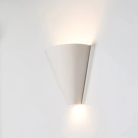 The Modern USA-Made Gotlandia Sconce by A19 Artisan Lighting, handcrafted in California, features a white cone shape and energy-efficient LED bulbs that softly illuminate upward and downward on a plain white wall.