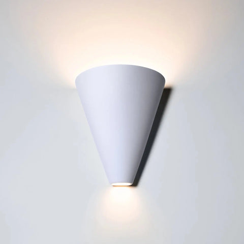 The Modern USA-Made Gotlandia Sconce by A19 Artisan Lighting, handcrafted in California, features an inverted cone design and energy-efficient LEDs to cast a soft upward and downward glow on any white wall.