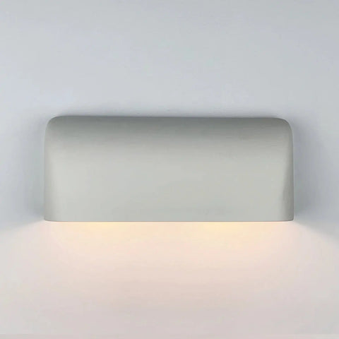 The Gran Balboa Downlight Sconce by A19 Artisan Lighting is a handcrafted, USA-made wall light with a sleek, rounded-edge design that casts a warm up-and-down glow on any white wall.