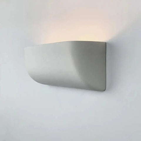 The Gran Balboa Sconce by A19 Artisan Lighting is a modern, handcrafted white ceramic wall light made in California, featuring a smooth curved design and energy-efficient LED for soft uplighting.