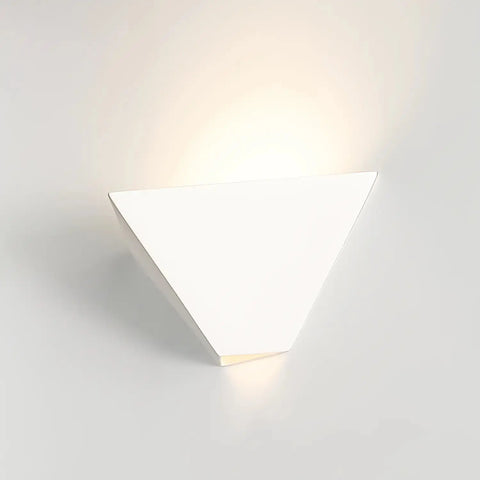 The Modern USA-Made Java Sconce by A19 Artisan Lighting, handcrafted in California, features an inverted white triangle design with LED smart bulbs glowing from the top and bottom against a light-colored wall.