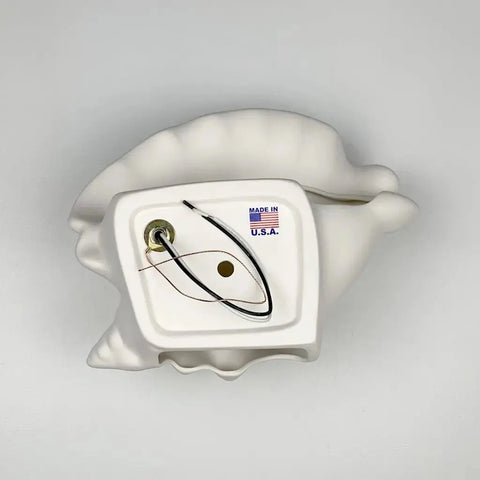 The Modern USA-Made Wall Lighting – Key West Sconce by A19 Artisan Lighting is a white ceramic, shell-shaped sconce handcrafted in California with exposed wiring and a Made in U.S.A. label, shown against a plain gray background.