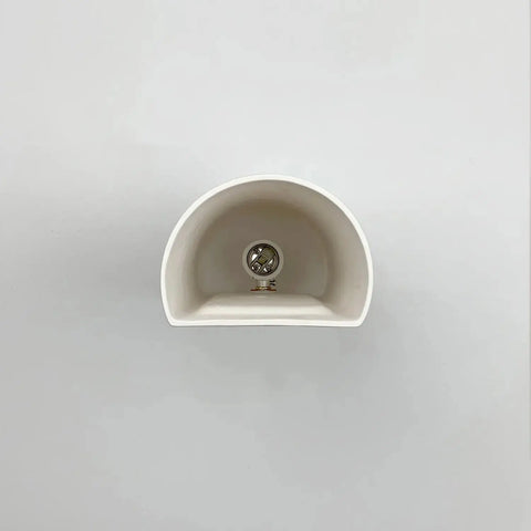The Kos Sconce by A19 Artisan Lighting is a handcrafted, white, semi-circular wall light made in California, shown front-facing with a central metal screw against a light gray background. Perfect for use with LED smart bulbs.