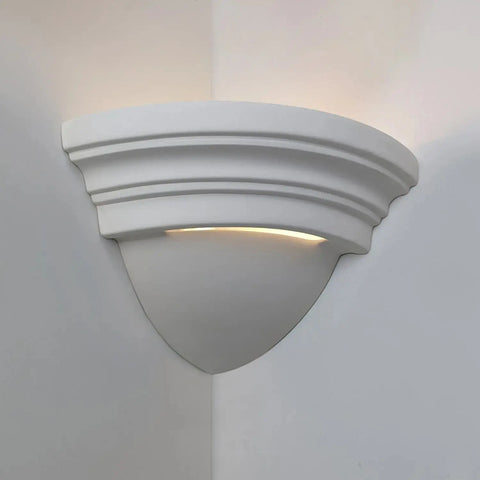 A white ceramic corner sconce with an up light pattern, suitable for indoor or covered outdoor use.