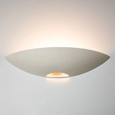 The Oahu Sconce by A19 Artisan Lighting is a modern, USA-made wall light with a curved white shade that casts a gentle upward glow; each piece is handcrafted in California for the perfect blend of style and craftsmanship.