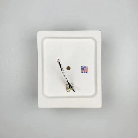 The Samos Sconce by A19 Artisan Lighting is a modern, handcrafted ceramic wall light in white, shown on a plain gray background. Made in California, it features minimalist design and a discreet “Made in U.S.A.” marking near the center.