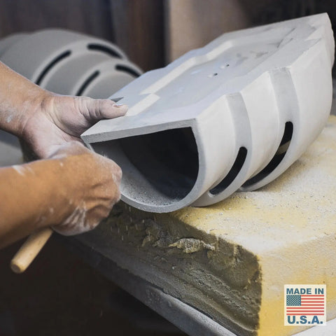 A person crafts the Modern USA-Made Wall Lighting – San Marcos Sconce by A19 Artisan Lighting, shaping it by hand on foam. A Made in U.S.A. label with an American flag appears in the corner. Handcrafted in California.